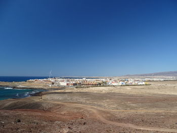 Scenic view of beach against clear blue sky