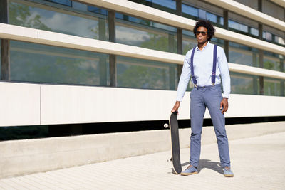 Portrait of young man standing against railing