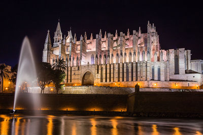 Illuminated buildings against sky at night