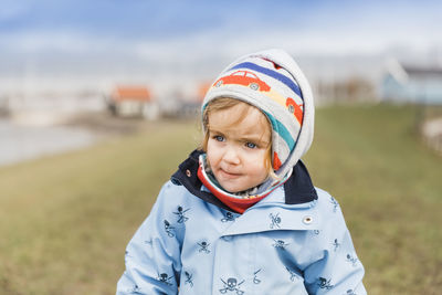 Girl looking away while standing on field during winter
