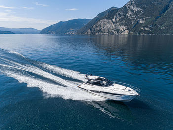 High angle view of boat sailing on sea against mountain