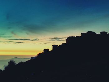 Silhouette buildings against sky during sunset