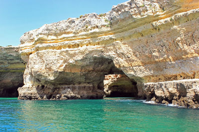 Scenic view of rock formation in sea against sky