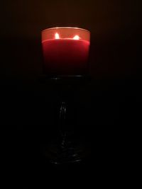 View of lit candle in dark room
