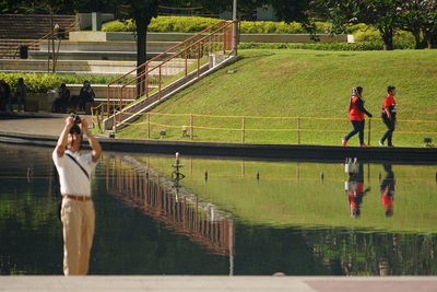 Rear view of people standing on footbridge