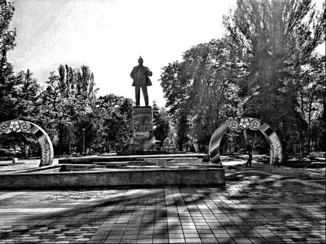 tree, statue, sculpture, art and craft, human representation, art, clear sky, fountain, park - man made space, creativity, built structure, day, travel destinations, architecture, outdoors, animal representation, footpath, growth, incidental people