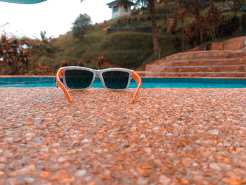 Sunglasses on sand at beach against sky