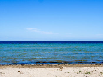 Scenic view of sea against blue sky