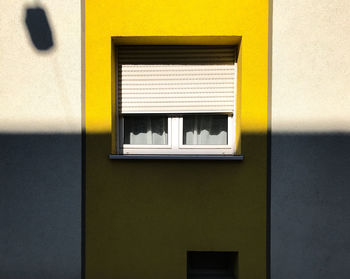 Close-up of yellow window on wall