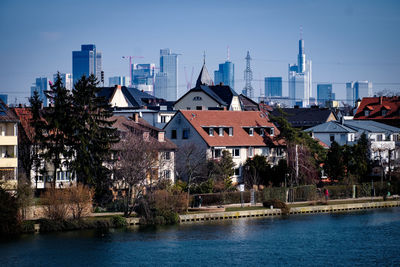 River by buildings in city against sky