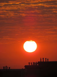 Silhouette built structure against romantic sky at sunset