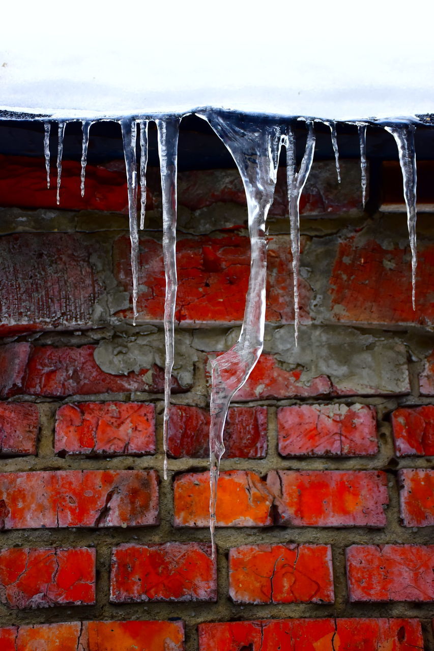 FULL FRAME SHOT OF ICICLES ON WALL