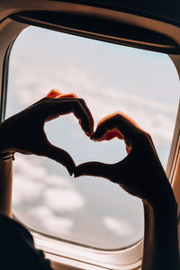 Female hand in heart shape airplane flight. view from the window of the plane. airplane, aircraft. 