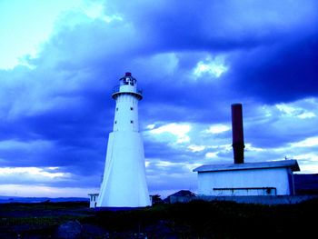 Low angle view of lighthouse against cloudy sky