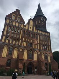 Low angle view of historical building against cloudy sky