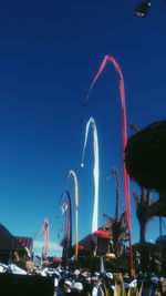 Low angle view of illuminated ferris wheel against blue sky