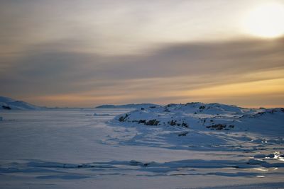 Scenic view of snowcapped landscape against sky during sunset