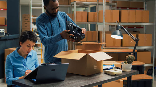 Portrait of man using digital tablet while standing in office