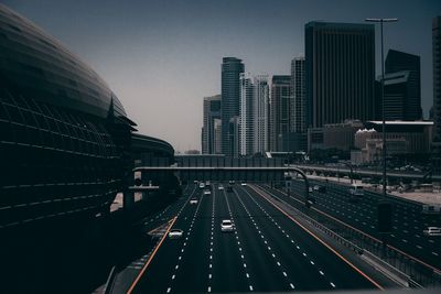 Road amidst buildings in city against sky