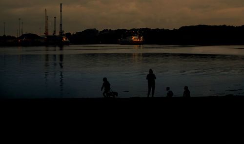 Silhouette men on boat against sky during sunset