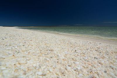 Scenic view of beach against clear blue sky