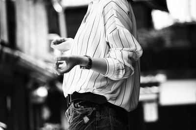 Midsection of woman standing outdoors at night