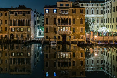 Reflection of residential buildings on the grand canal in venice at night.