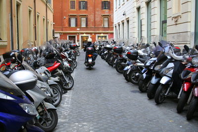 Bicycles parked on street amidst buildings in city