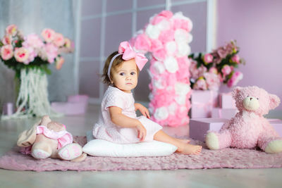 Cute baby girl sitting in toy at home