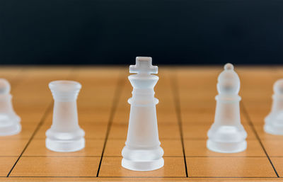 Close up chess pieces on a wood chessboard