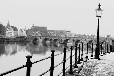 Bridge over river in city against clear sky