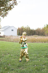 Cute blonde boy dressed in golden ninja halloween costume