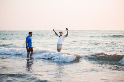 Two people enjoying themselves in the water by the beach