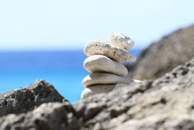 Low angle view of pebbles on rock against sky