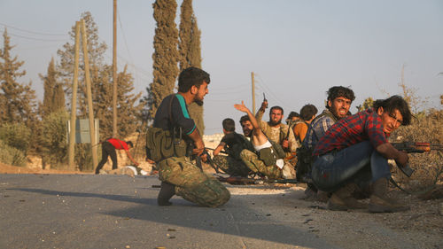 People sitting on road against sky