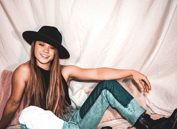 Portrait of smiling young woman lying in bed