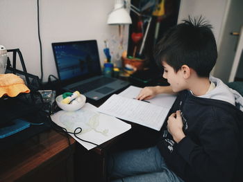 Boy sitting on table at home