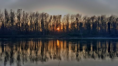 Scenic view of lake against sky at sunset