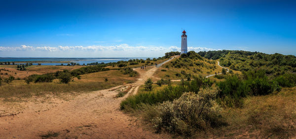 Lighthouse by sea against sky