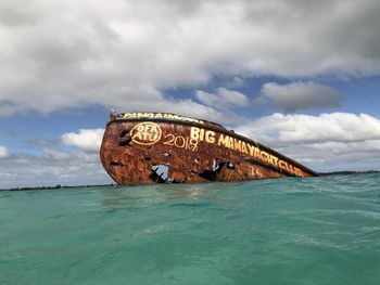 View of rusty ship on sea against sky