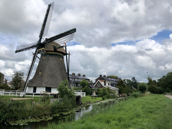 Traditional windmill on field against sky