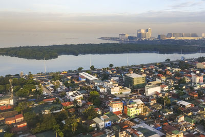 High angle view of buildings and bay against sky