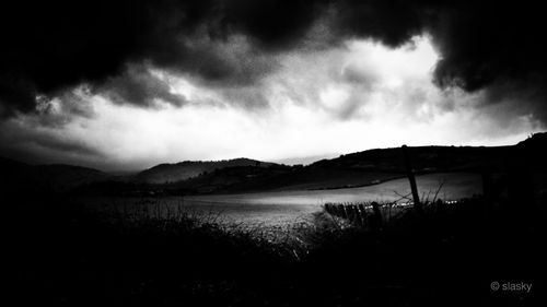 Scenic view of mountains against cloudy sky