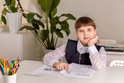 A girl pupul sits at a desk in the classroom and reads a book. back to school concept