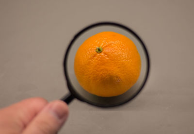 Close-up of hand holding orange slice