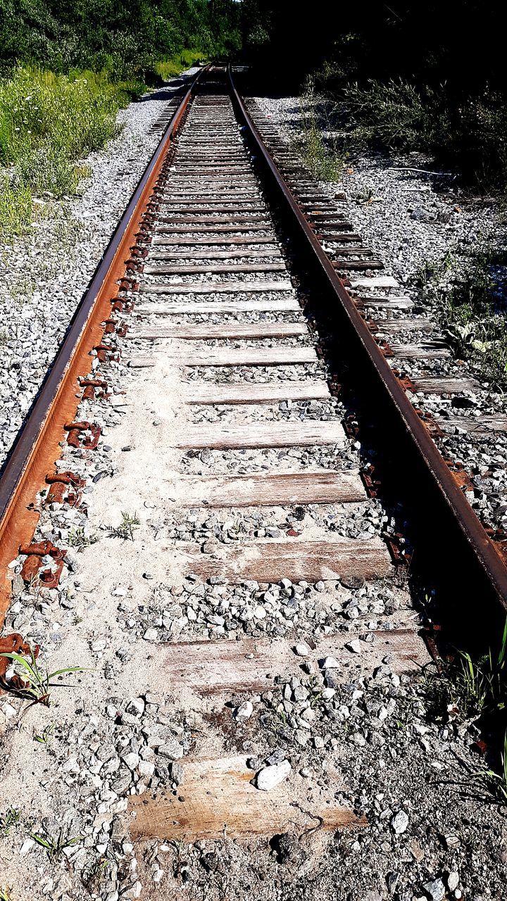 rail transportation, track, railroad track, transportation, no people, plant, metal, the way forward, nature, direction, day, diminishing perspective, high angle view, vanishing point, gravel, outdoors, solid, tree, railroad tie, stone - object, parallel, long