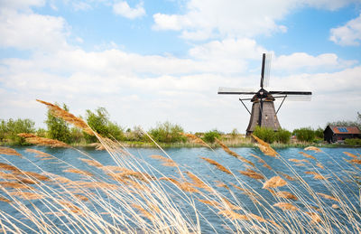 Traditional windmill on landscape against sky