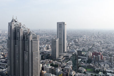 Aerial view of buildings in city against sky