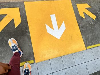 Low section of man standing on street. directions. light rail transit.