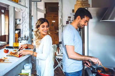 Young man and woman standing at home